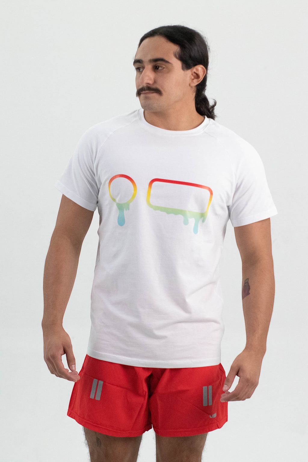 Model wearing a white Robfrank.com FLUX SPORT SHIRT with a colorful rainbow drip graphic on the chest.