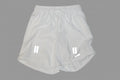 White athletic shorts with drawstring on a light gray background