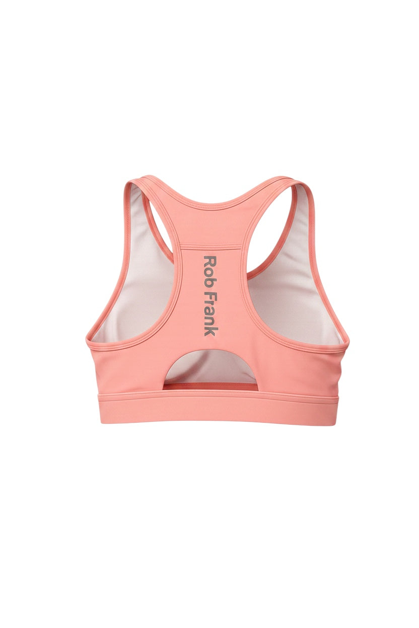 Robfrank.com coral pink racerback sports bra with moisture-wicking fabric, reflective logo, and cutout back detail.